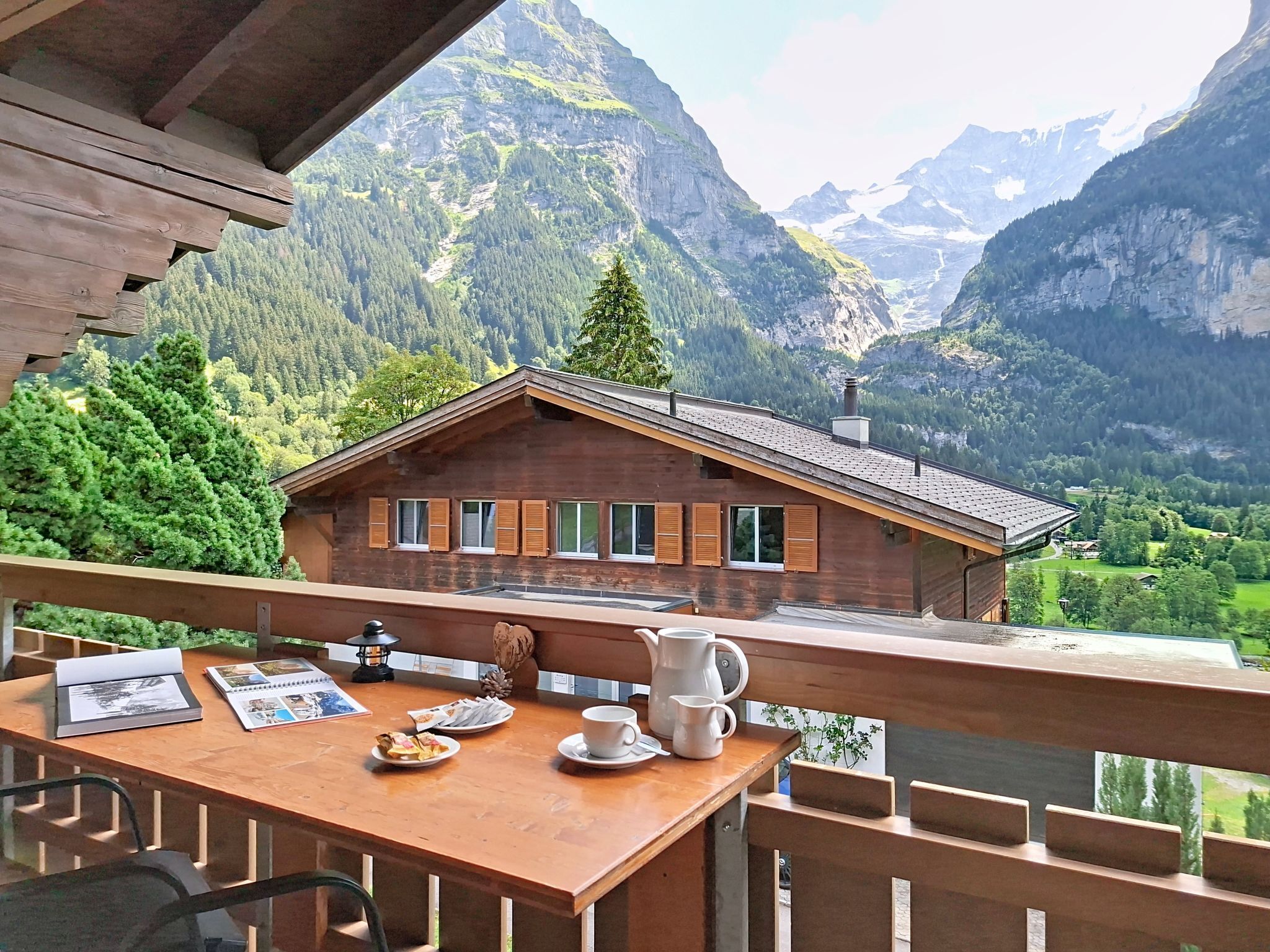 Une cabane en bois dotée d’un balcon donnant sur un paysage montagneux.