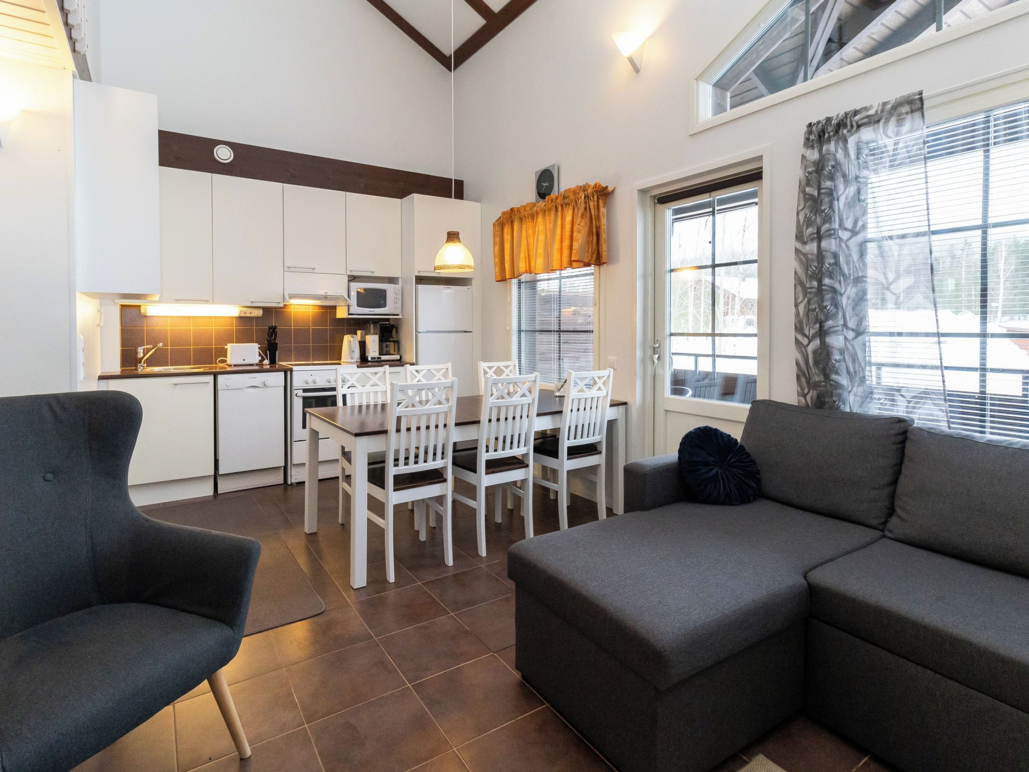 A compact living space with a kitchenette, dining area, and seating area.