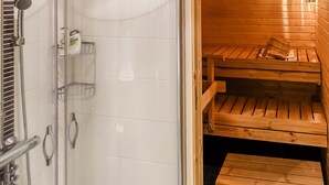 A sauna room with wooden benches and a glass-enclosed shower area. - Sallan panparkstie 14 b by Interhome (Salla)