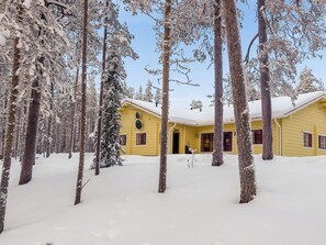 Un edificio amarillo rodeado de árboles cubiertos de nieve.