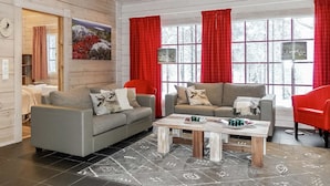 A cozy living room with two sofas, a coffee table, and red curtains. - Sallan panparkstie 14 b by Interhome (Salla)