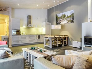 Un salon moderne comprenant un coin repas, une cuisine et une cheminée.