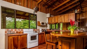 Une cuisine avec des meubles de rangement en bois, une cuisinière et un four à micro-ondes.