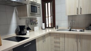 Una cocina moderna con microondas, cafetera y lavamanos.