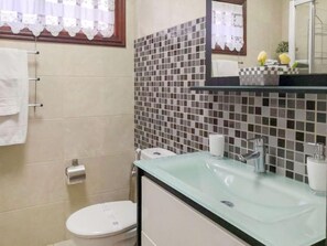 Ein Badezimmer mit Toilette, Waschbecken und Spiegel.