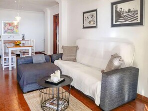 A living room with a sofa, a coffee table, and a dining area with a table and chairs.