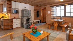 A cozy cabin interior with a kitchen, dining area, and a fireplace.
