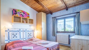 A bedroom with two beds, a wooden ceiling, a window with curtains, and a radiator. - Les Jardins de Sinople by Interhome (Saint Cyr sur Mer La Madrague)