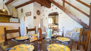 A dining table set with yellow plates, wine glasses, and cutlery. - Les Jardins de Sinople by Interhome (Saint Cyr sur Mer La Madrague)