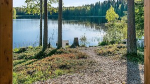 A lakeside view with a wooden deck and a dock extending into the water. - Lahdenpohja, vaikon loma 7 by Interhome (Kaavi)