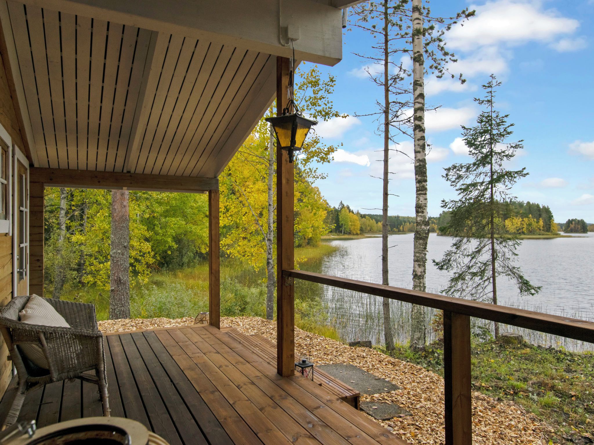 A wooden deck with a view of a lake and trees.
