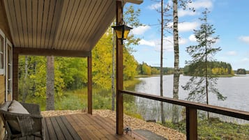A wooden deck with a view of a lake and trees.