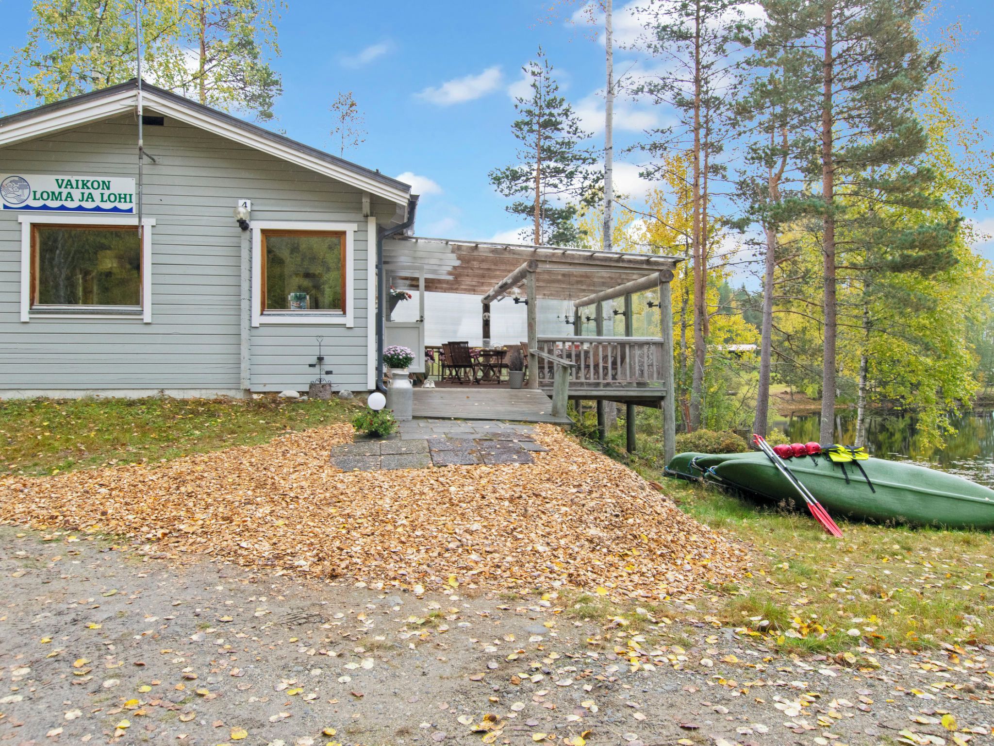 A cabin with a deck and a canoe.
