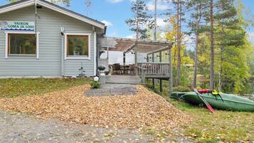 A cabin with a deck and a canoe.