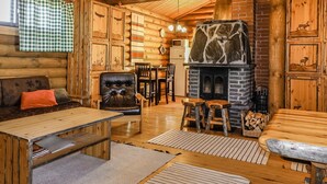 A log cabin interior with a fireplace, wooden furniture, and animal-themed decor. - Inarinlahti by Interhome (Inari)