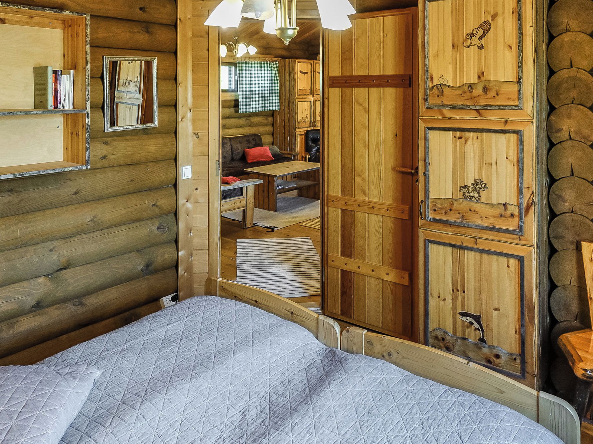 Een houten vakantiehuisje met een bed, een eethoek en een badkamer.