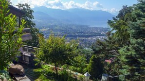 A view from a balcony overlooking a cityscape with mountains in the distance. - Noisette by Interhome (Le Mont-Pèlerin)