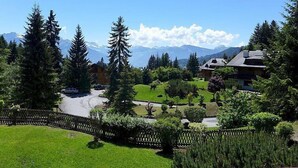 Zona residencial con casas, valla de madera y montañas al fondo.