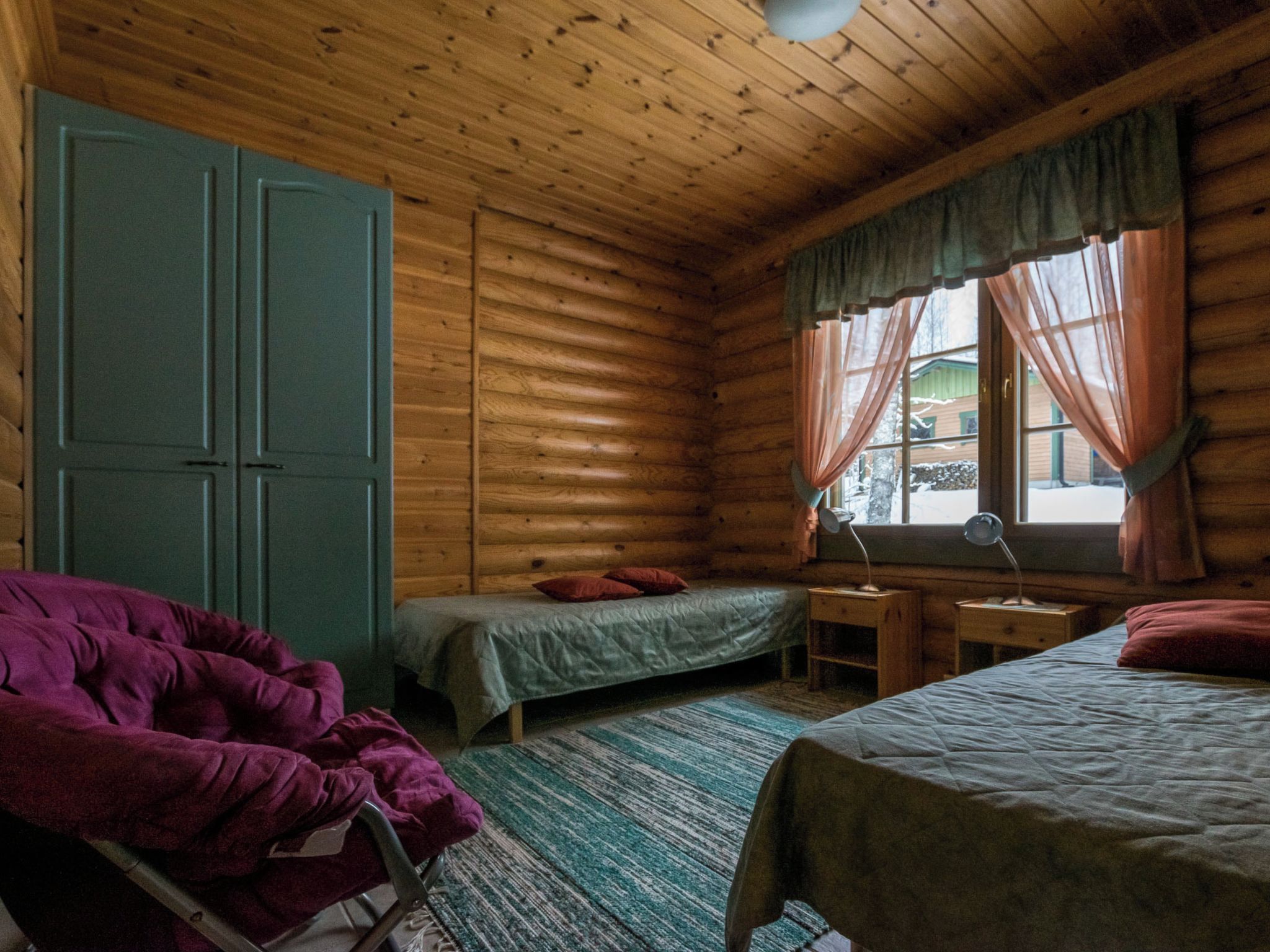 A cabin with two beds, a desk, and a chair.