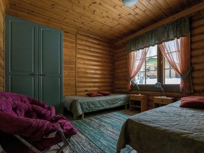 En stuga med två sängar, ett skrivbord och en stol.