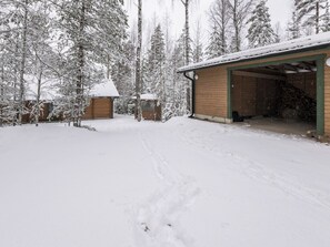 Une propriété enneigée comprenant un garage, des chalets en bois et un paysage hivernal.