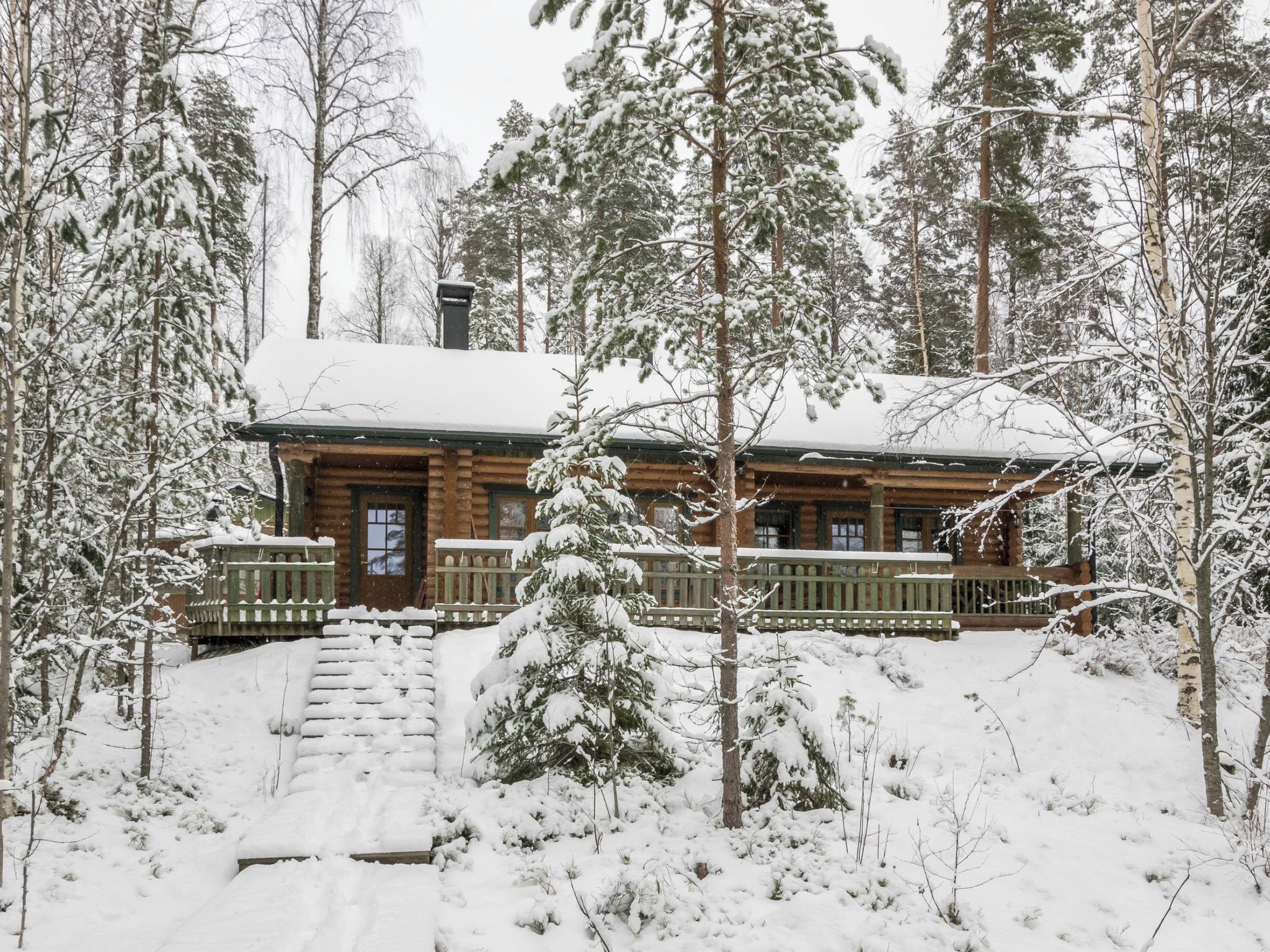 A log cabin surrounded by snow-covered trees.