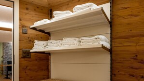 A wooden interior with a laundry basket and shelves holding folded towels. - Haus Alpenrose by Interhome (Saas-Almagell)