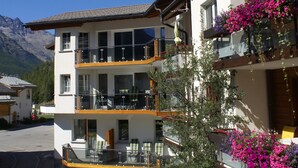 A two-story building with balconies, large windows, and a mountain backdrop. - Haus Alpenrose by Interhome (Saas-Almagell)