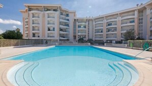 A modern apartment building with a central swimming pool, surrounded by a fence and featuring multiple balconies. - Apartment L'Open by Interhome (Fréjus)