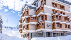 Ein mehrstöckiges Hotel mit Steinaußenwand und Holzelementen, namens "Le Grand Roc".
