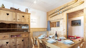 Ein Essbereich aus Holz mit einem Tisch für vier Personen, umgeben von Holzstühlen.