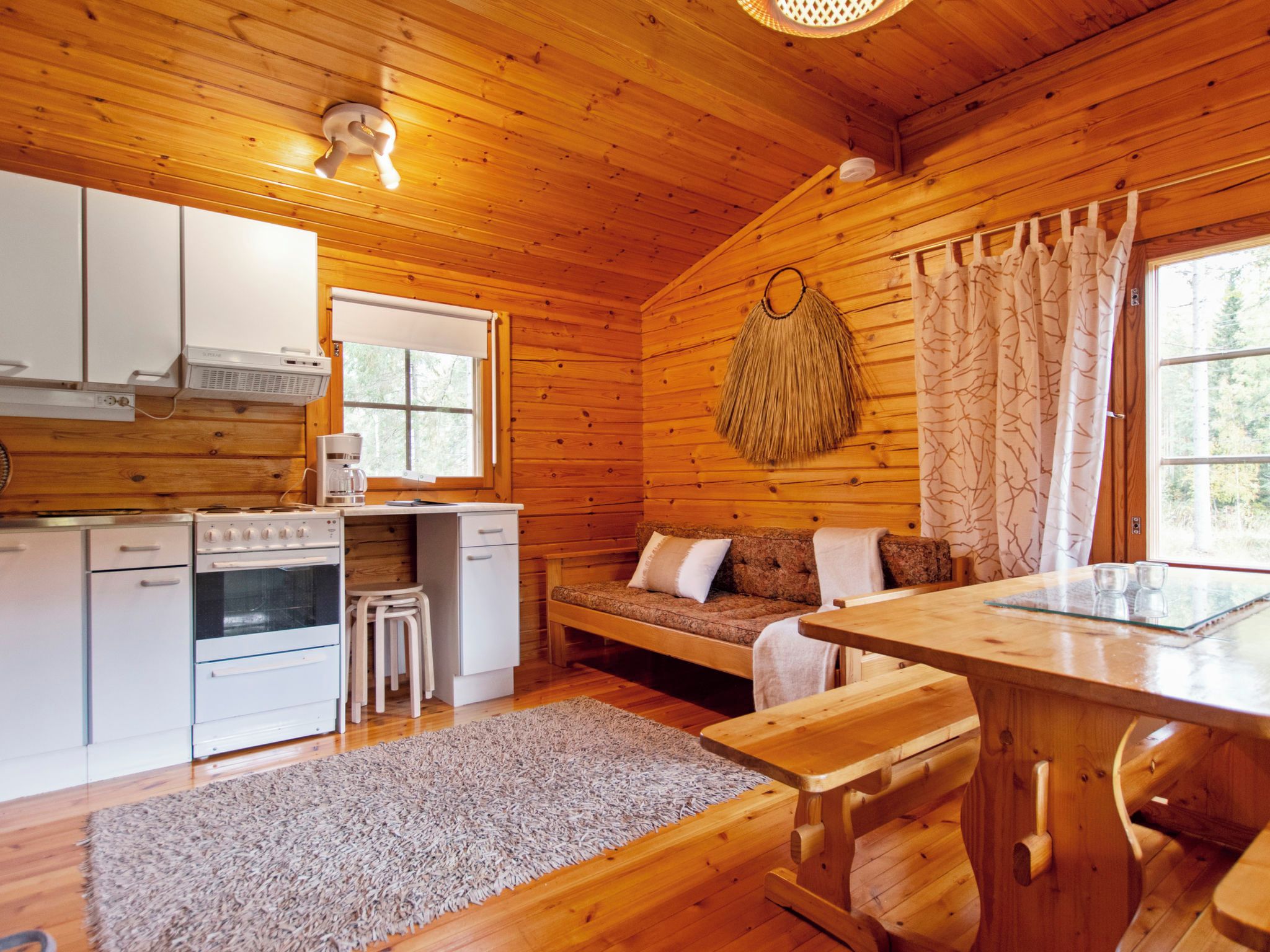 Een chaletinterieur met een keuken, eethoek en zithoek.