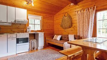 Een chaletinterieur met een keuken, eethoek en zithoek.