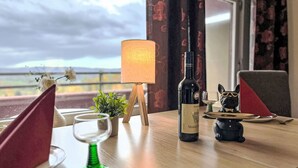 A dining table set with a wine bottle, a green candle holder, and a decorative cat figurine. - Braubach (B715) by Interhome (Lahnstein (Koblenz))