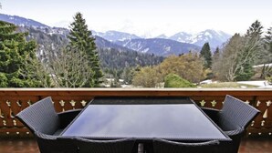 A balcony with a table and chairs overlooking a mountainous landscape. - Le Geteillon 4 by Interhome (Villars)