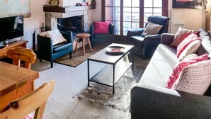 A cozy living room with a fireplace, a television, and comfortable seating. - Les Aiguilles d'Argent 10 by Interhome (Villars)