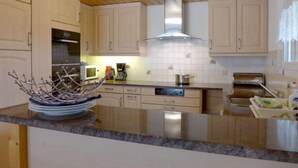 A modern kitchen with wooden cabinets, a stainless steel sink, and a built-in oven.