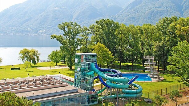 A resort with a pool, a water slide, and a mountain backdrop. - Residenza Lido Appartment 008 by Interhome (Locarno)