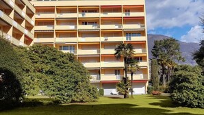 A multi-story hotel with balconies and a view of a mountain. - Residenza Lido Appartment 008 by Interhome (Locarno)