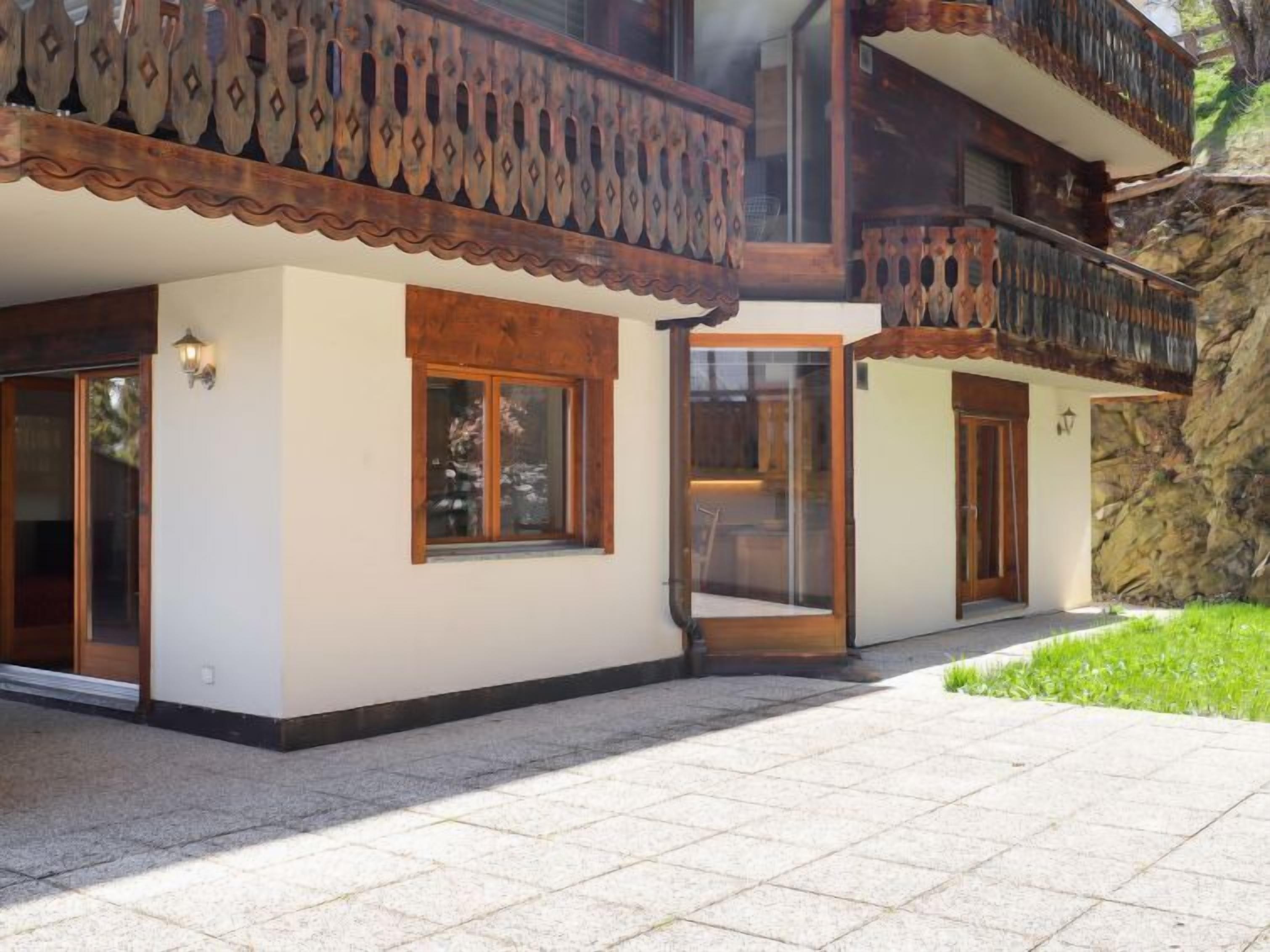 Un immeuble de deux étages doté d’un balcon, de grandes fenêtres et d’une façade en pierre.