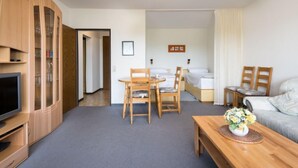 A hotel room with a dining area, a sofa, a TV, and a cabinet. - Kiefer (A907) by Interhome (Lahnstein (Koblenz))