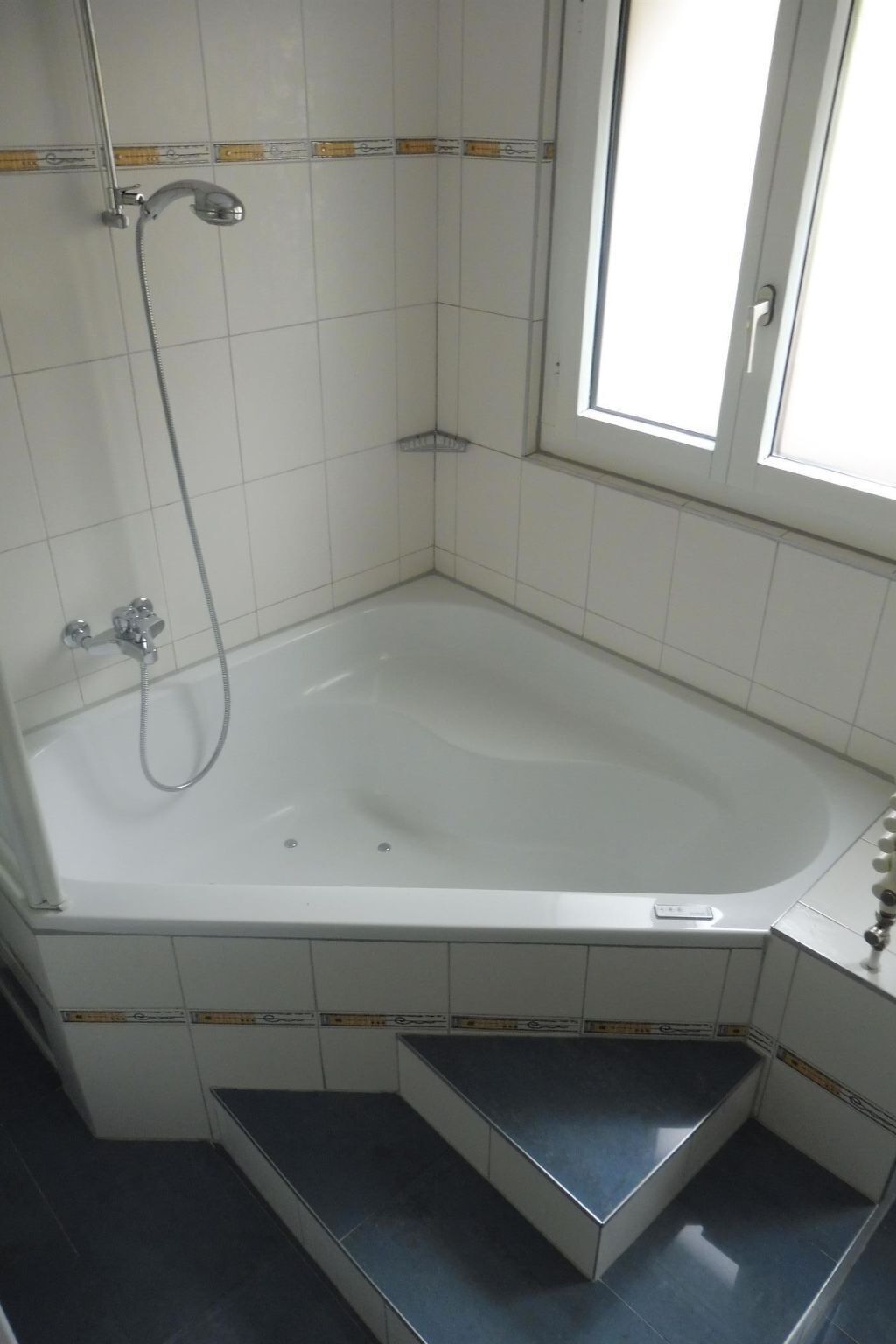 Un bagno con vasca, doccia e finestra.