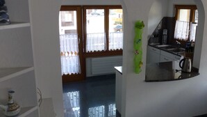 A kitchen with a sink, a kettle, and a window with curtains. - Theresli by Interhome (Saas-Almagell)