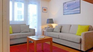 A living room with two sofas, a wooden coffee table, and a lamp. - Apartment Roger by Interhome (Zermatt)