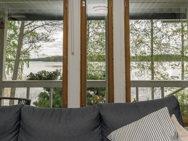 A room with a view of a lake and trees through large windows. - Rantapelto by Interhome (Mikkeli)