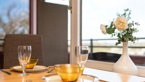 A dining table with two wine glasses, a bowl, and a vase with a flower. - Baumblick (B610) by Interhome (Lahnstein (Koblenz))