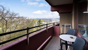 A balcony with a table and chairs, offering a view of buildings and trees. - Baumblick (B610) by Interhome (Lahnstein (Koblenz))