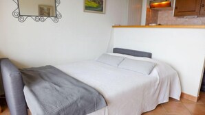 A bedroom with a bed, a bedside table, a mirror, and a window. - Les Girolles B14 by Interhome (Villars)