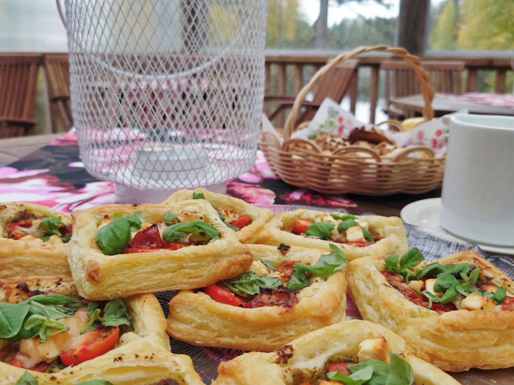 A table with food items, a basket, and a cup.