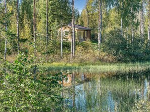 A cabin surrounded by dense forest and a calm lake. - Koskenniska, vaikon loma 1 by Interhome (Kaavi)